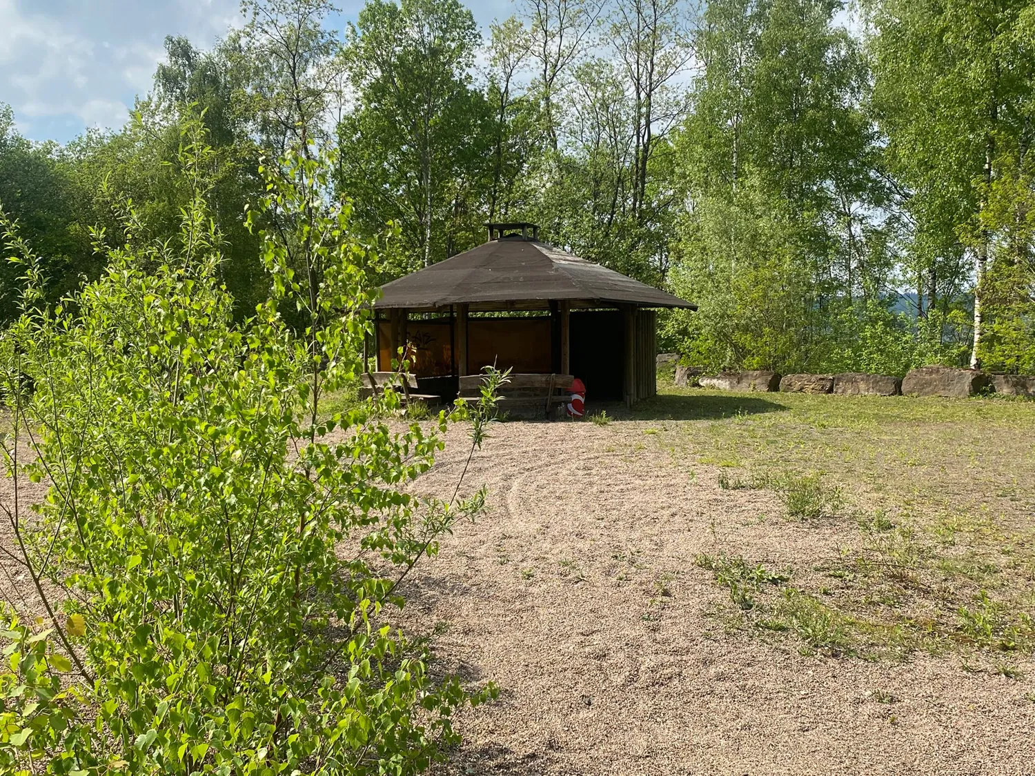 Holz-Unterstand auf der Wiese des Geländes